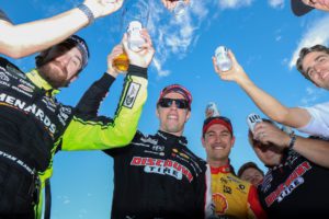 Brad keselowski, joey logano and ryan blaney cheer to keselowski's success with team penske during the "beer chug" after the 2021 nascar cup championship race at phoenix raceway. Photo by rachel schuoler / nigel kinrade photography