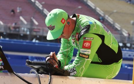 Kyle Busch takes a look at the tablet to review performance data from the Next Gen car. Photo by Rachel Schuoler with Kickin' the Tires.