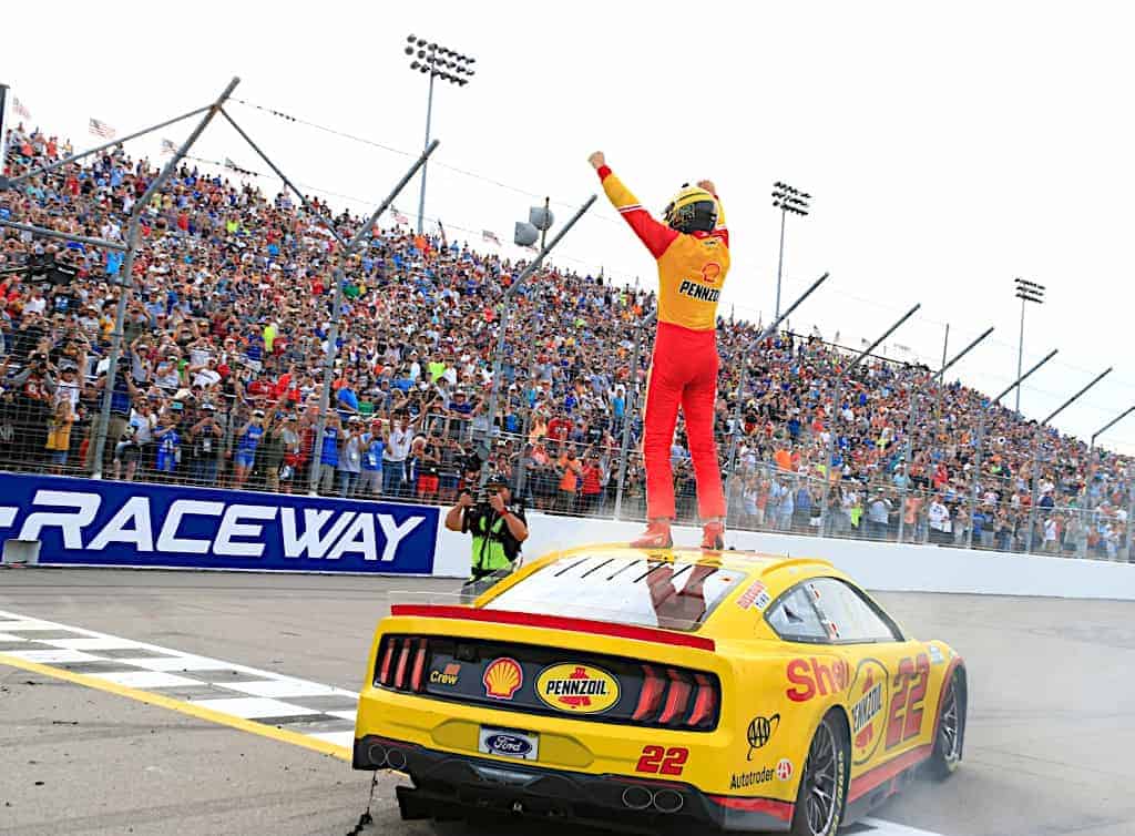 Joey Logano takes the checkered flag after exchanging the lead with Kyle Busch in the closing laps of the NASCAR race at World Wide Technology Raceway near St. Louis.
