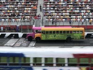 Kaulig racing gives back to short track racing as landon cassill, justin haley, daniel hemric, and chris rice raced school buses in the cook out summer shootout at charlotte motor speedway.