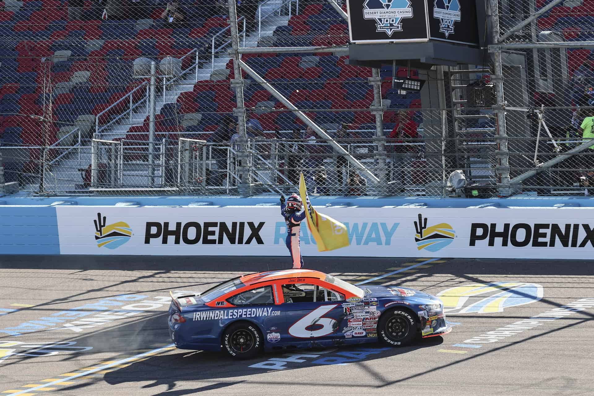 Jake drew waves the championship flag after winning the 2022 arca menards series west title. Photo by rachel schuoler / kickin the tires.