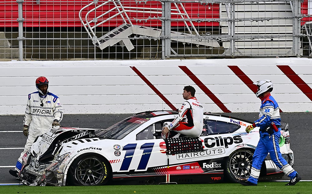 Denny Hamlin is approached by safety workers as he exits his battered Toyota Camry. Photo by Rusty Jarrett/NKP